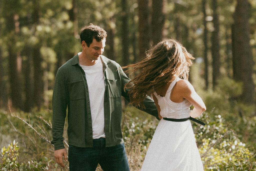 man and woman in white dress spin in woods of Khale Park Nevada