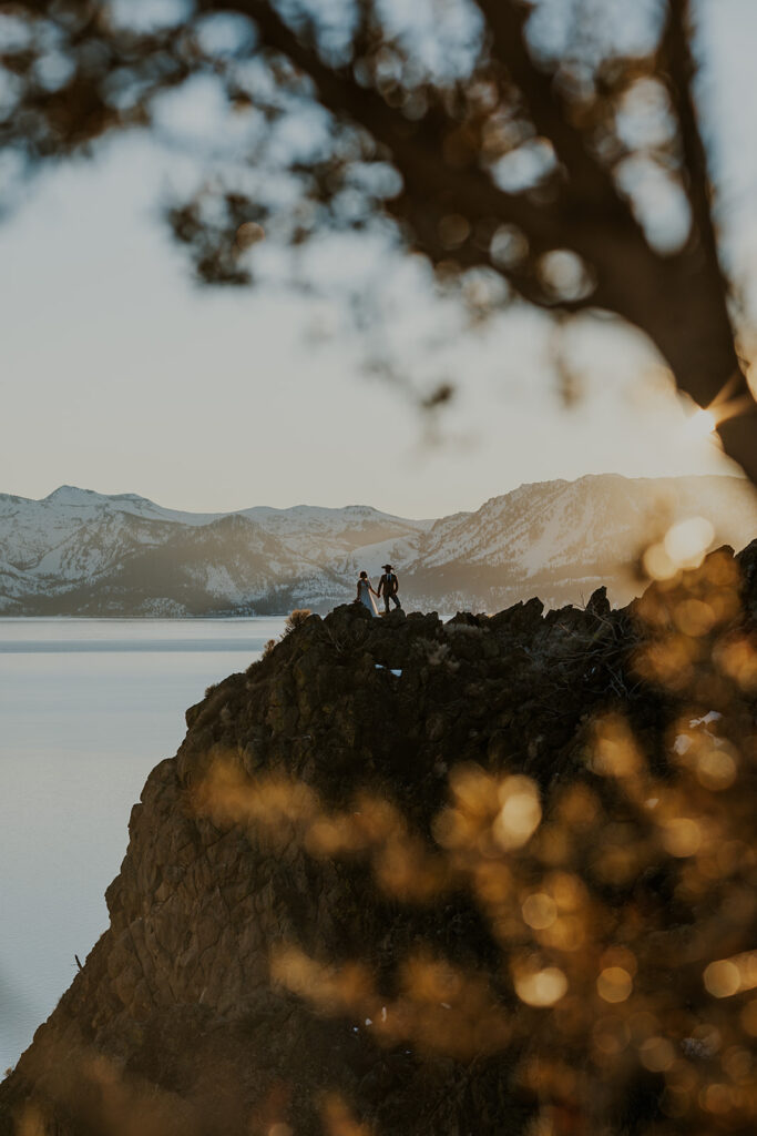 Man and woman stand at overlook on wedding day at Cave Rock Nevada 