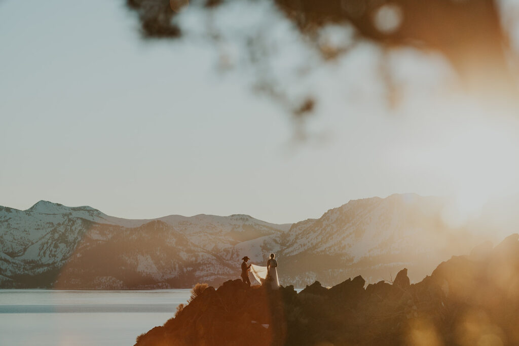 Man and woman stand at overlook on wedding day at Cave Rock Nevada 