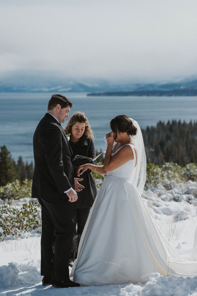 husband and wife in white wedding dress saw vows at Carnelian Bay Overlook