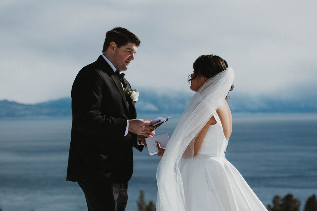 husband and wife in white wedding dress saw vows at Carnelian Bay Overlook