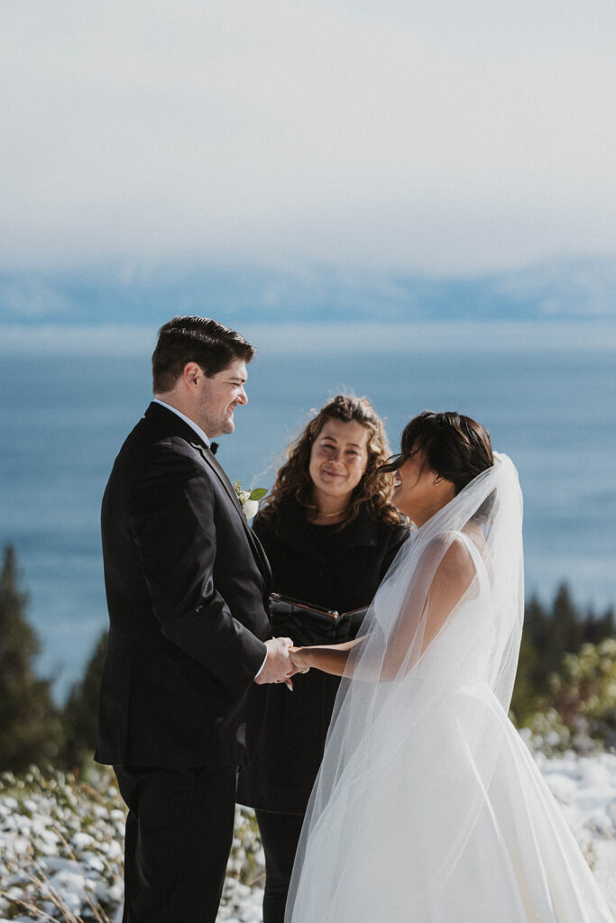 husband and wife in white wedding dress saw vows at Carnelian Bay Overlook